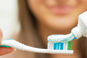 Woman putting toothpaste on a toothbrush