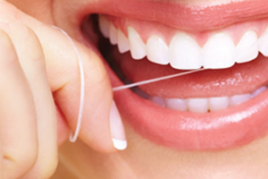 Woman flossing her white and straight teeth