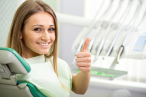 Woman giving a thumbs up before a dental procedure