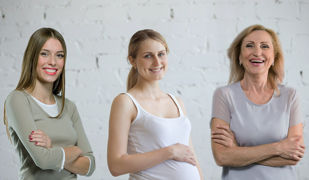 A teen, a pregnant woman, and a middle-aged woman smiling