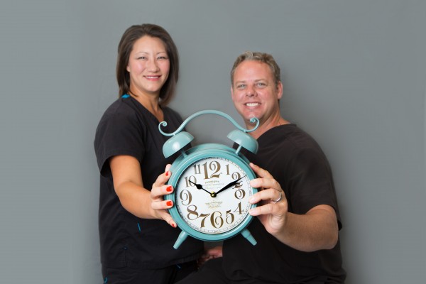 Dentists at Cobblestone Park Family Dental in Oklahoma City holding an alarm clock