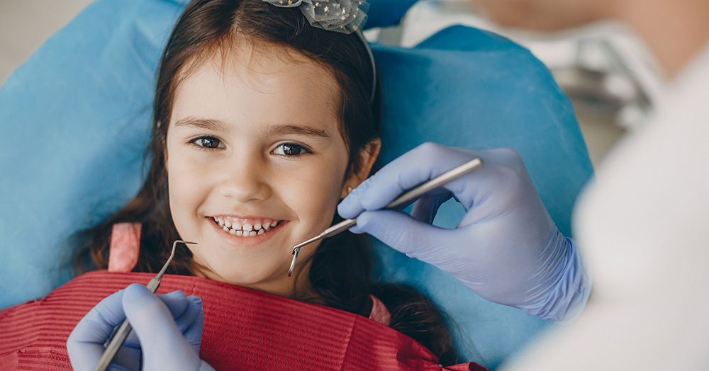 Kid smiling in a dentist chair